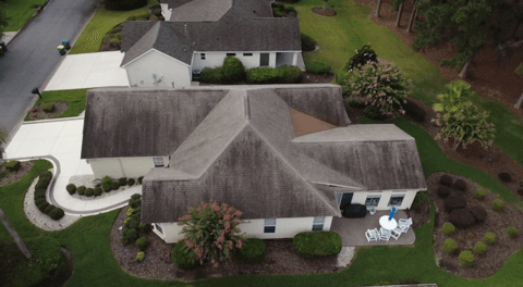 Aging asphalt roof that is dry, faded, and streaked before rejuvenation